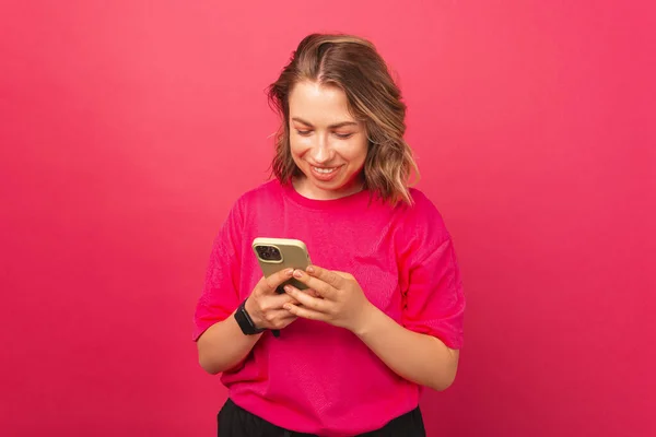 Mulher Sorridente Loira Brilhante Vestindo Camiseta Rosa Está Navegando Seu — Fotografia de Stock