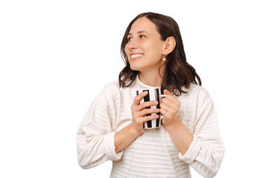 Bir fincan sıcak bitki çayıyla ısınan neşeli genç bir kadının fotoğrafı..