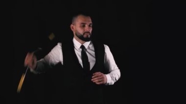 Siyah arka planda güçlü bir adamın klasik üniforma içinde nunchaku çalışması..