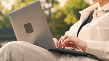 Parkın dışındaki dizüstü bilgisayarda çalışan ve daktilo eden kadınların videosunu kapat..