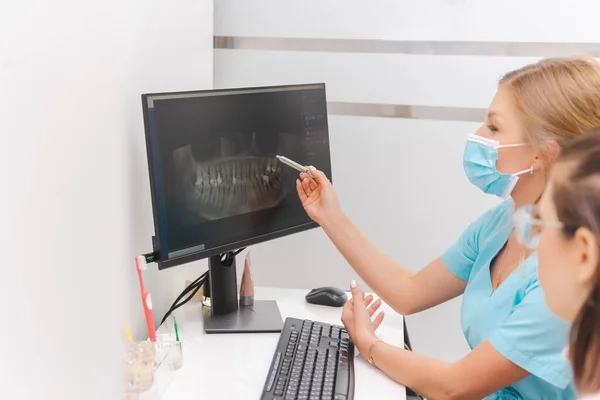 Vrouwelijke Tandarts Draagt Beschermmasker Legt Patiënt Röntgenfoto Van Het Computerscherm — Stockfoto