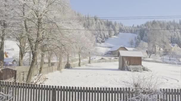 雪の中でルーマニアの村で冬の素晴らしい景色の美しい運動パニング映像 — ストック動画