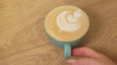 Kadın elinin bir fincan kapuçino servis ettiği görüntüleri kapatın..