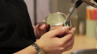 Kahve ya da kapuçino için sütü sürahide hazırlarken çekilen görüntüleri kapat..