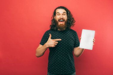 Bu tablet ekranda gösterdiğim teklife bakın. Stüdyoda duran sakallı bir adam diyor ki:.