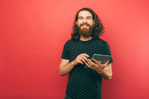 Long Hair Bearded Man Holds Modern Tablet While Smiling Camera — Stock Photo, Image