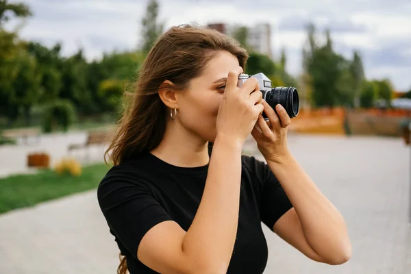 在一个刮风的日子里 美丽的年轻女子正在用她的老式照相机拍照 — 图库照片