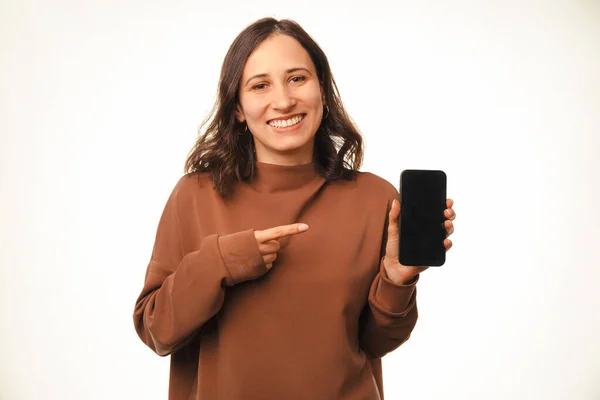 Smiling Cute Young Woman Pointing Phone Screen She Holding Studio — Stock Photo, Image