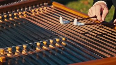 Dışarıdaki cimbalom müzik enstrümanında çalan müzisyenin görüntülerini kapat..
