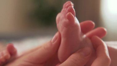 Anne ellerinin yatak odasında bebek ayaklarına masaj yaptığı görüntüleri kapat..