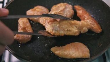 Close up footage of preparing chicken meat in frying pan.