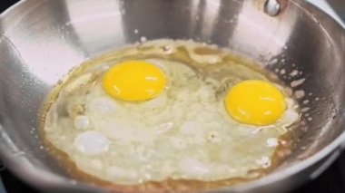 Close up footage of chef preparing omelette in frying pan.