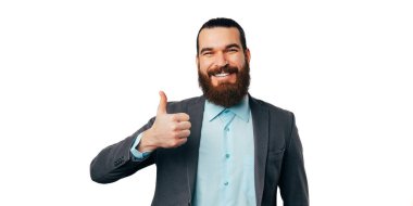 Handsome bearded man wearing jacket is holding thumb up for appreciation over white background.