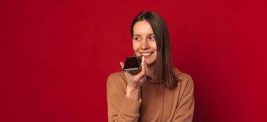 Banner ebadında, hoparlörden konuşan hoş bir genç kadının görüntüsü..