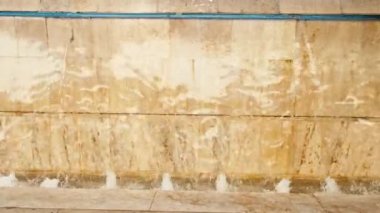 Close up footage of little waterfall in city.