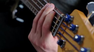 Close up video of man playing at bass guitar.
