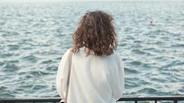 Πλάνα Από Νεαρή Σγουρή Γυναίκα Στέκεται Μπροστά Από Κύματα Του — Αρχείο Βίντεο