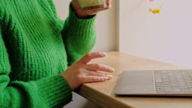 Close up video of young woman drinking matcha in cafe near window.
