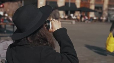 Şehirde dışarı çıkmak için bir fincan kahve içen bir kadının videosu..