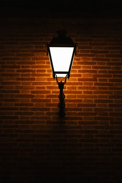 Vertical Shot Brick Wall Warm Light Lamp Outdoors Night Time — Φωτογραφία Αρχείου