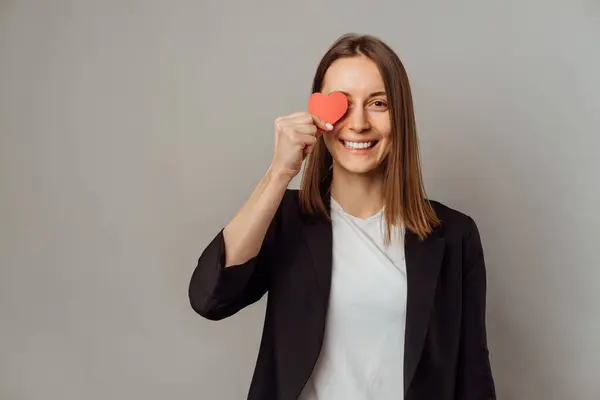 Przyjazna Uśmiechnięta Kobieta Ubrana Kurtkę Zakrywa Jedno Oko Małym Czerwonym — Zdjęcie stockowe