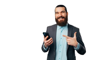 İnternette, beyaz arka planda tuttuğu telefonu işaret eden sakallı bir adam yazıyor..