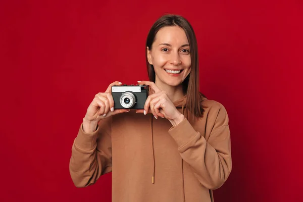 Neşeli Bayan Fotoğrafçı Kırmızı Arka Planda Yüzünün Yanında Klasik Bir — Stok fotoğraf