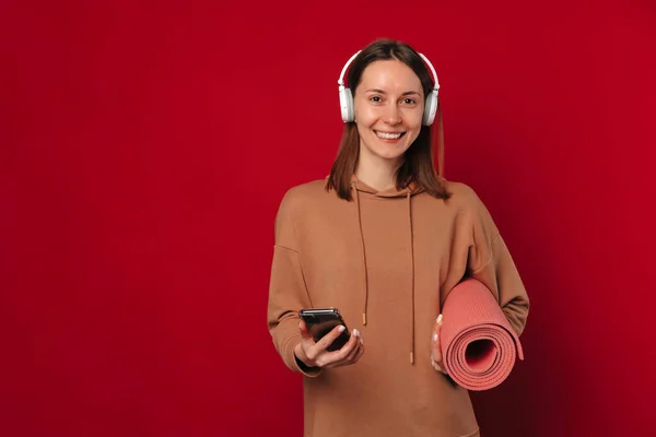 Sorridente Donna Forma Indossando Cuffie Sta Tenendo Suo Telefono Fitness — Foto Stock