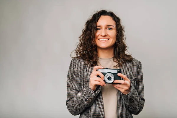 Ecstatic Young Curly Woman Wearing Jacket Holding Vintage Camera Front — Stock Photo, Image