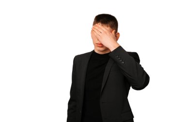 Ceket giyen yakışıklı, hayal kırıklığına uğramış adam beyaz arka planda avuç içi ile yüzünü kapatıyor..