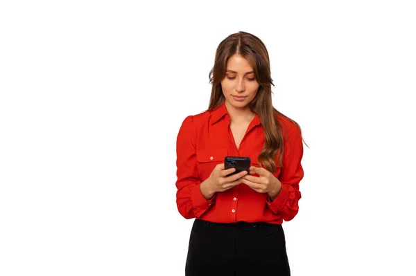 Молодая Серьезная Женщина Красной Рубашке Печатает Телефону Просматривает Интернет — стоковое фото