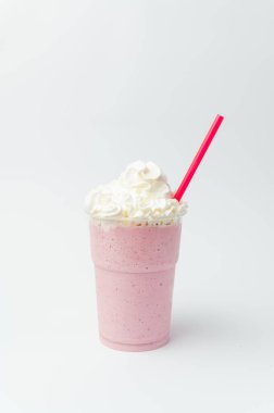 Çilekli milkshake 'in dikey pozu. Üstünde krema ve pipet var..