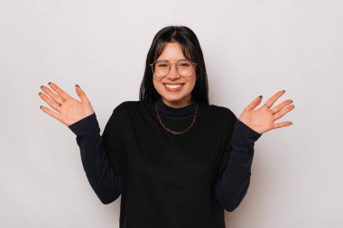 Neşeli, genç, şaşkın, gülümseyen bir kadın el ele tutuşuyor. Gri arka planda sarılmak için..