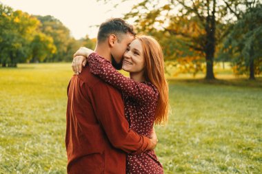 Genç yakışıklı bir adam gün batımında parkta kadınını kucaklarken bir sır söyler..