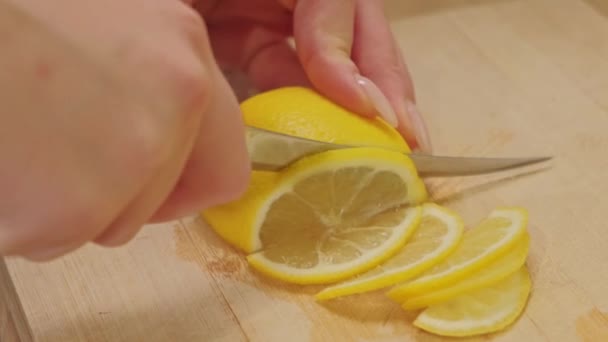 女性の手を閉じるまな板の上にレモンをスライス — ストック動画