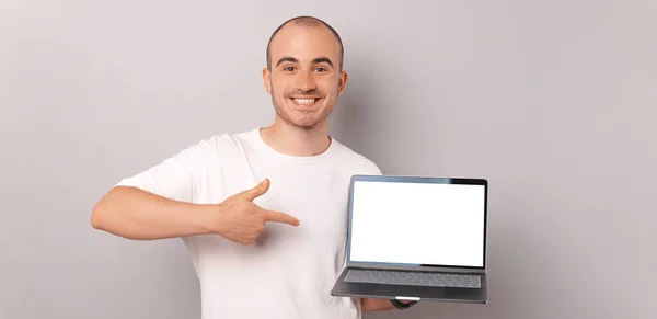 Gri Arkaplanda Dizüstü Bilgisayarı Gösteren Kel Bir Adamın Afiş Boyu — Stok fotoğraf