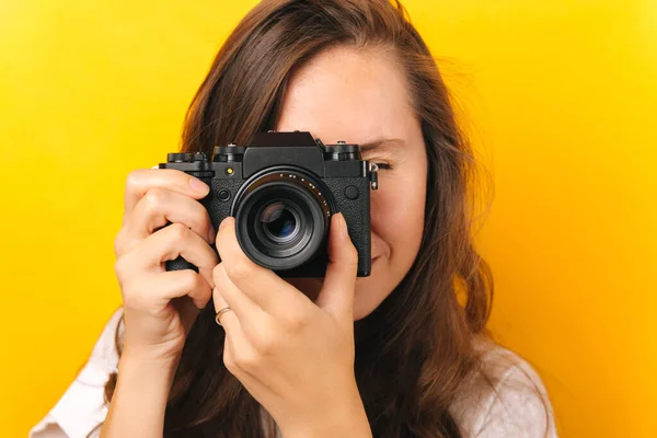 Sarı Arkaplanda Profesyonel Bir Kamerayla Fotoğraf Çeken Genç Bir Kadının — Stok fotoğraf