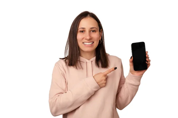 Красивая Молодая Женщина Указывает Чистый Экран Телефона Который Держит Студия — стоковое фото