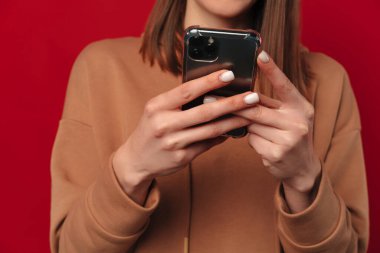 Kırmızı arka planda elinde telefon tutan ve daktilo yazan genç bir kadının meçhul görüntüleri..