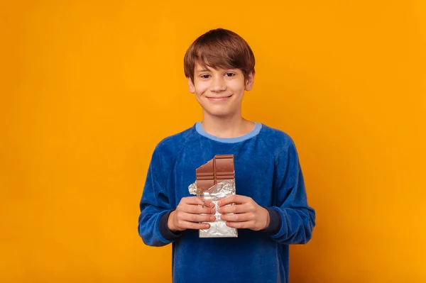 Красивий Усміхнений Молодий Хлопчик Тримає Трохи Молочного Шоколаду Жовтому Тлі — стокове фото