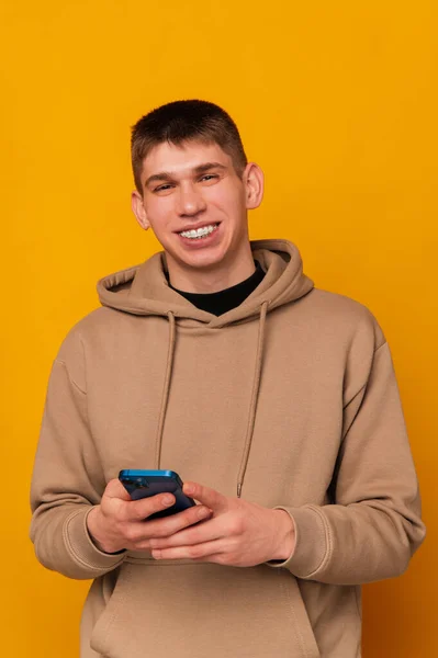 Вертикальний Студійний Знімок Молодого Усміхненого Чоловіка Який Тримає Синій Смартфон — стокове фото