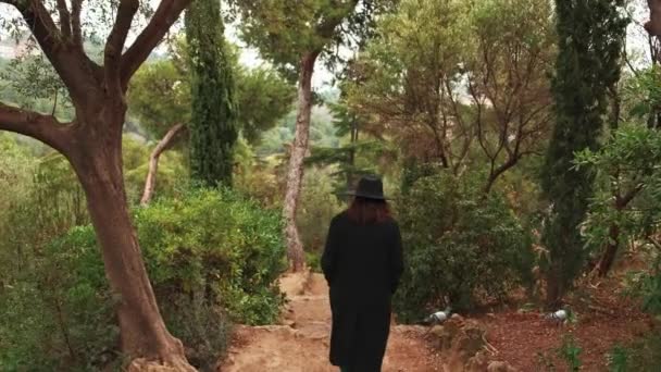 Відеозапис Молодої Жінки Чорному Капелюсі Пальто Йде Зеленому Парку Барселоні — стокове відео