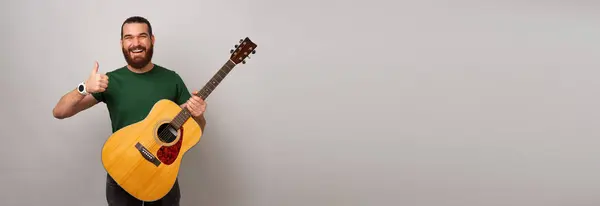 Baner Wystrzelony Miejsca Kopiowania Brodatego Mężczyzny Trzyma Gitarę Akustyczną Kciuk — Zdjęcie stockowe