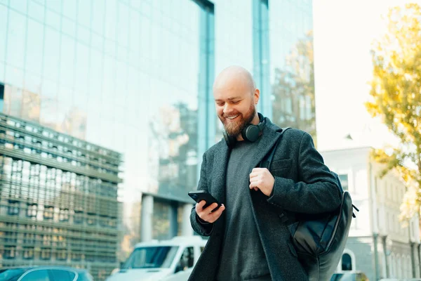 Outdoor Shot Bald Man Walking Streets Looking Phone While Carry — Stock Photo, Image