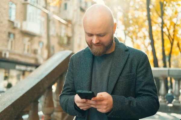 Sunny Outdoor Shot Bald Man Looking Phone Holds While Walking — Stock Photo, Image