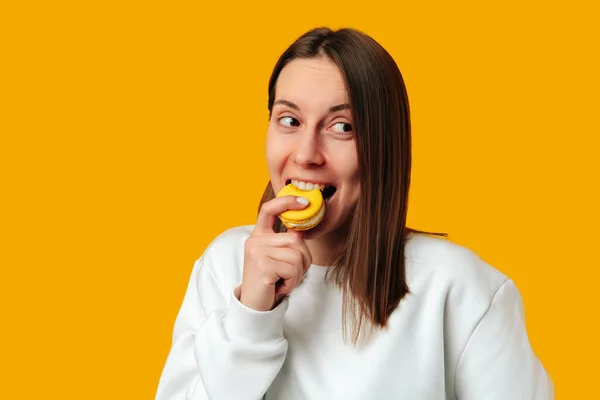 Studio Portrait Playful Young Woman Taking Bite Yellow Macaroon Yellow — Stock Photo, Image
