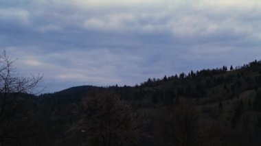 Akşamları bulutlu tepelerin üzerinden geçen zaman çizelgesi.