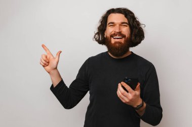 Telefonunu tutan mutlu sakallı adam açık gri fotokopi alanını gösteriyor..