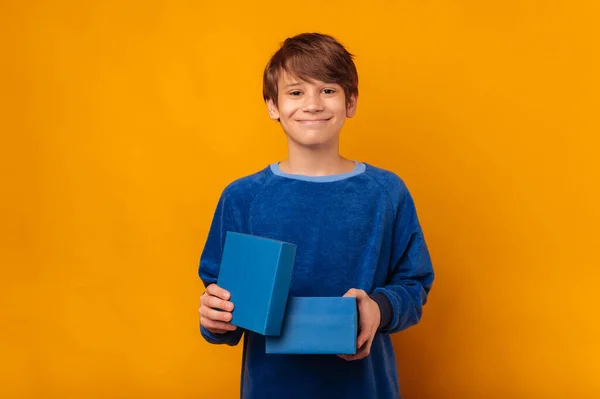 Милий Усміхнений Хлопчик Тримає Синю Маленьку Відкриту Подарункову Коробку Жовтому — стокове фото