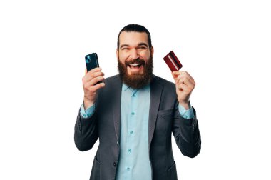 Genç sakallı adam cep telefonu bankacılığı ve nakit paranın yeni kartıyla geleceği için çok heyecanlı.. 